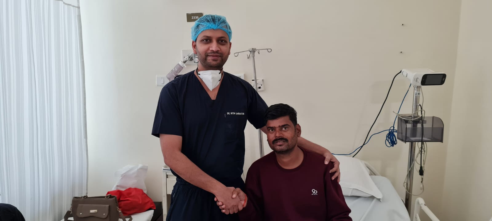 Dr. Nitin Shrivastava shaking hands with a recovering kidney stone patient
